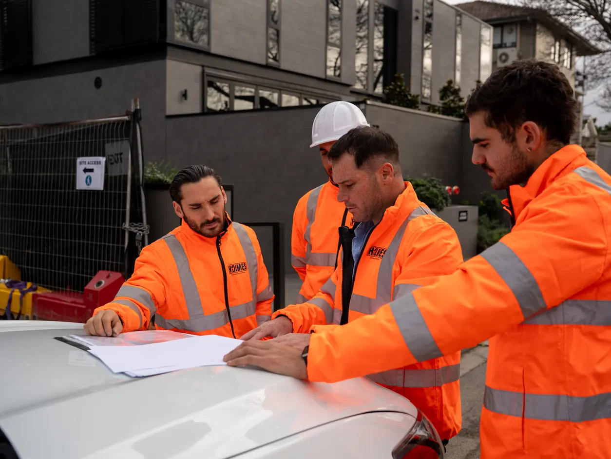 Holmes Plumbing team reviewing plans on site