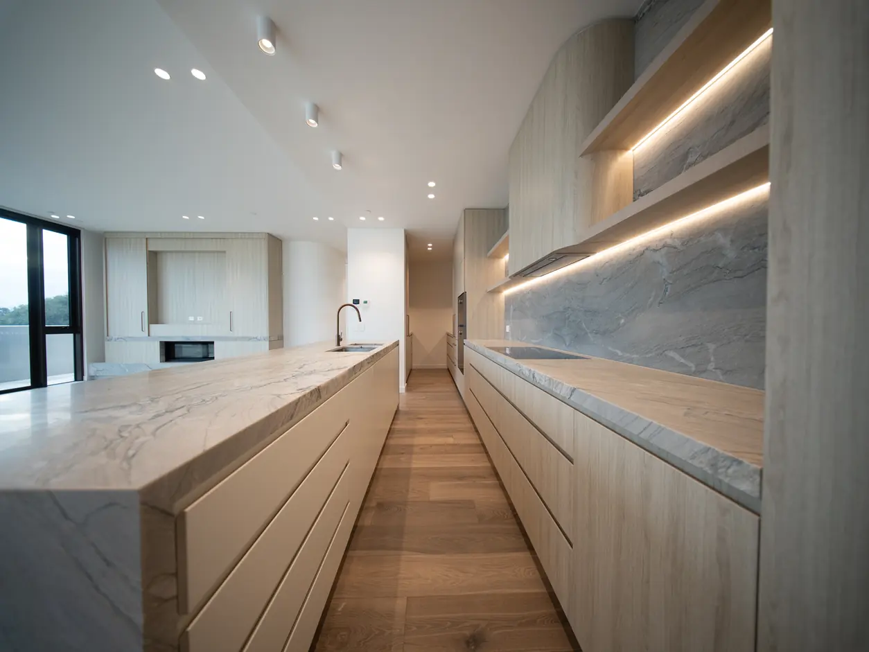Long galley kitchen with stone benchtops and timber joinery