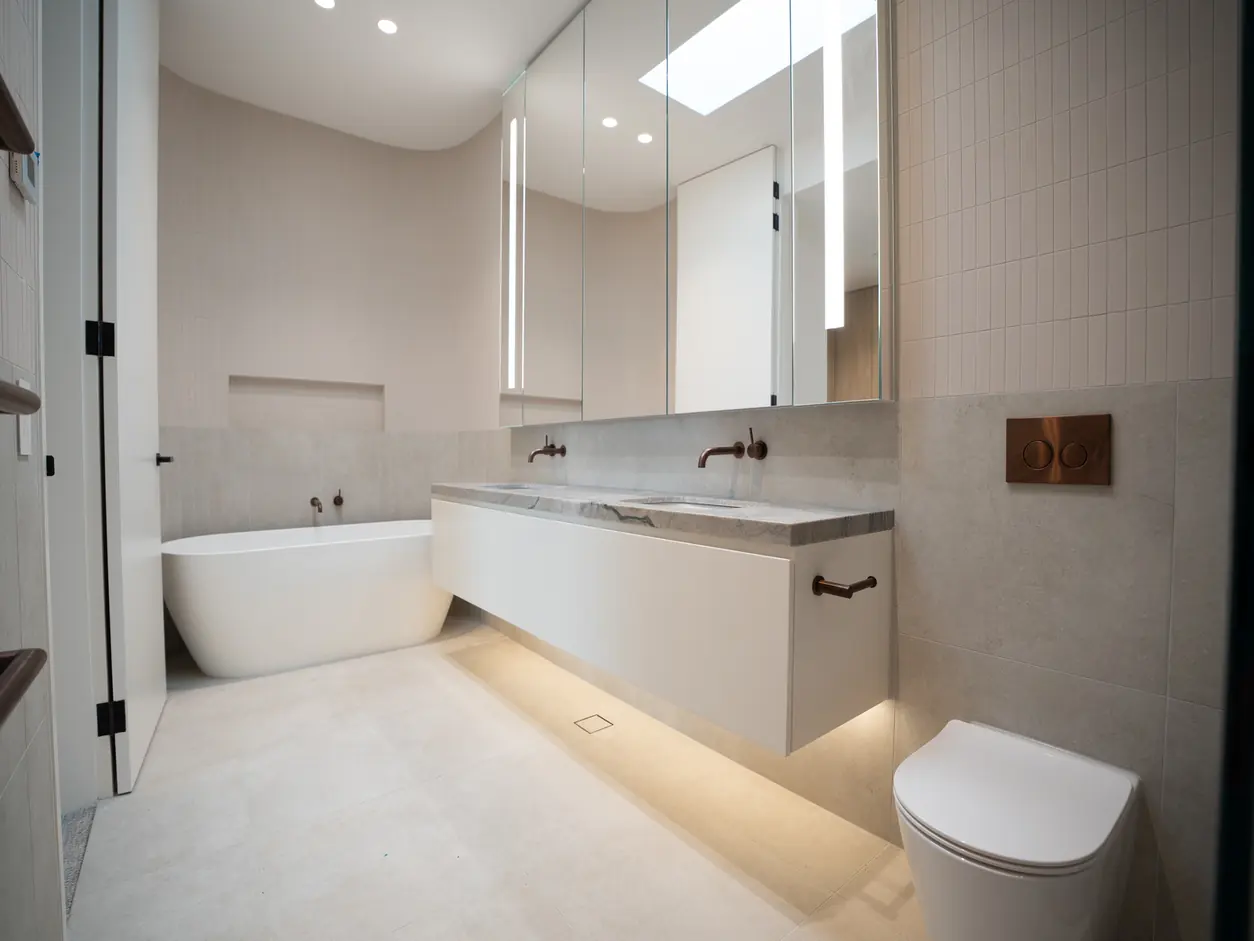 Bathroom with a freestanding bath, floating vanity and brushed bronze tapware