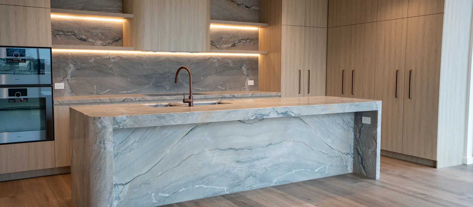 Kitchen with a stone island and timber joinery in a Kover luxury apartment