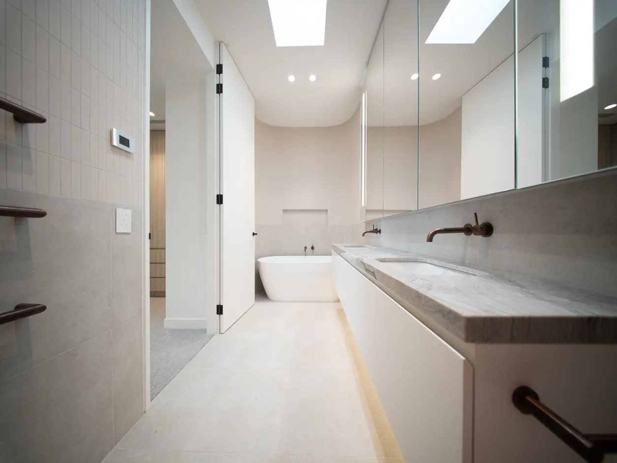 Ensuite with a stone vanity and floor-to-ceiling mirrors